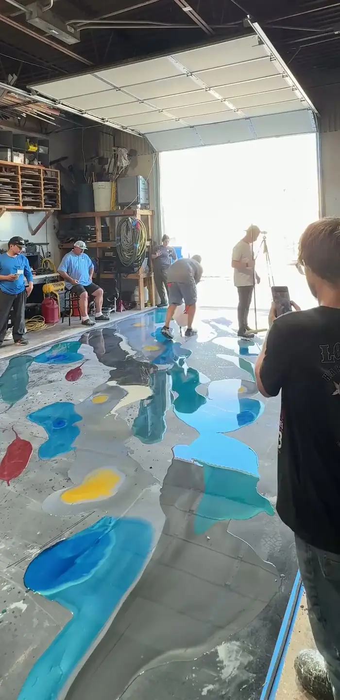 Crew installing a decorative epoxy floor in a workshop