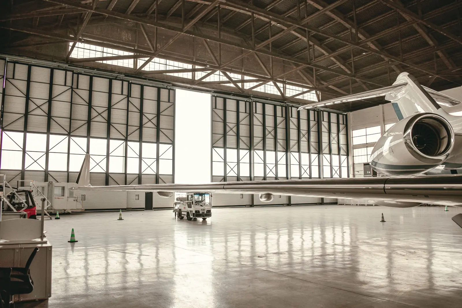 Private jet parked in a hangar with a reflective floor