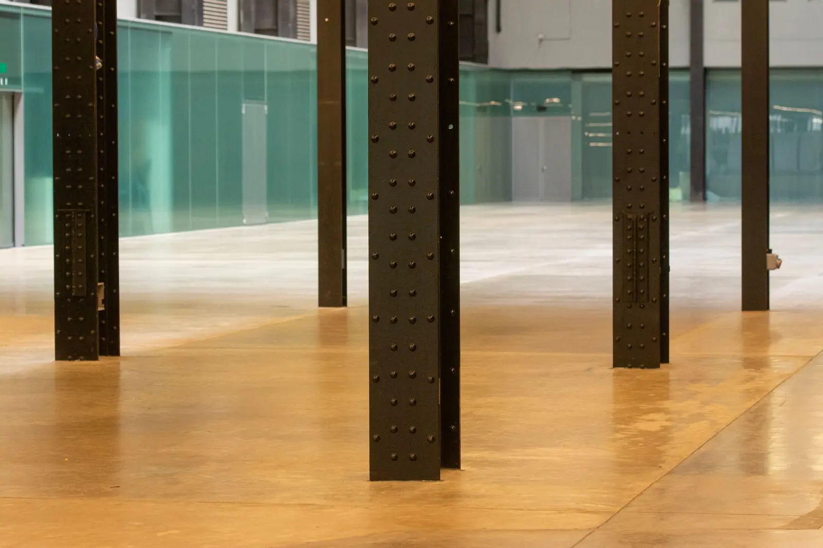 Large hall with a warm-toned polished concrete floor and steel columns